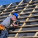 Worker drilling into commercial roof replacement