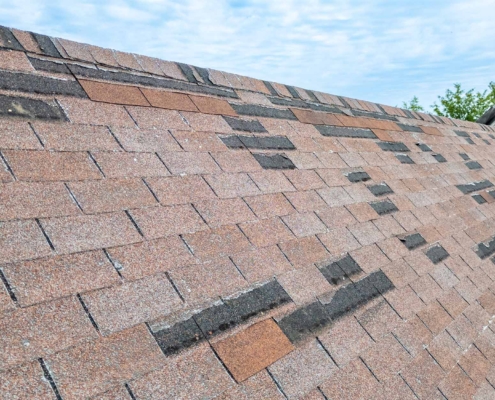 Roof with damaged shingles from storm